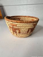 Side view of handmade coiled basket showing color pattern and shape