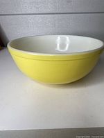 Side view of large yellow ceramic mixing bowl with white interior