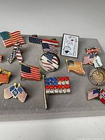 All ten lapel pins displayed on grey surface