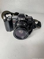 Front view of Minolta Maxxum 7000 with lens and strap visible