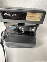 Front view showing Polaroid logo, flash, lens, viewfinder and strap