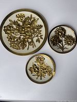 Overview of all three brass floral wall plaques