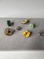 All eight lapel pins laid out on felt background