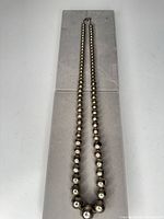 Full view of graduated bead necklace laid flat