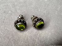 front view of both earrings showing green cabochons and bead settings
