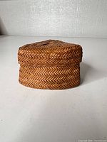 Front view of triangular wicker basket with lid in place