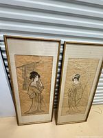 Both framed portraits standing side by side for scale and condition