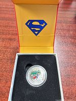 Coin in capsule within opened Superman presentation box