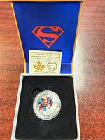 Coin in capsule inside presentation box showing Superman logo