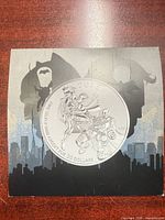 Obverse view of coin against themed display sleeve