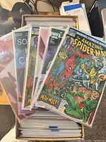 Top view of long box showing bagged comics, front issue The Amazing Spider-Man (Marvel) with Man-Wolf cover, additional issues behind