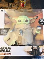 Front view of boxed Grogu figure with accessories visible