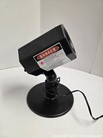 projector on base showing danger label and cord