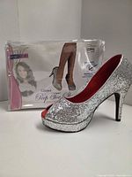 Right shoe on display with packaging showing brand and style