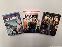 Front view of all three Veronica Mars season DVD box sets
