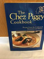 Front cover of The Chez Piggy Cookbook showing the title, restaurant logo, and photo of a seafood soup dish.