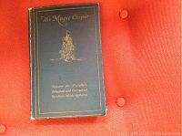 Front cover of the book 'The Magic Carpet' with gold embossed ship and title, showing some wear.