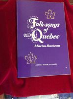 Front cover of the book 'Folk-songs of Old Quebec' by Marius Barbeau, showing purple cover with white text and maple leaf designs.