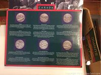 Display board showing nine commemorative coins with detailed descriptions of Canadian historical events.