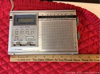 Front view of the Sears portable AM/FM radio with speaker, LCD quartz clock, clock control buttons, and tuning scale.