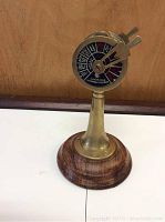 Full view of the brass nautical telegraph on wooden base showing dial with engine commands and two brass levers.