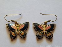 Front view of the pair of butterfly-shaped cloisonné earrings, showing colorful enamel and gold-tone detail.