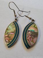 Pair of leaf-shaped sterling silver earrings with paua shell and turquoise inlay shown flat on white background.
