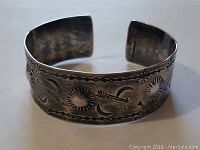 Front view of sterling silver cuff bracelet showing detailed etched geometric and nature-inspired pattern.