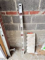 Full view of 48" aluminum level leaning against concrete wall