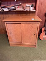 Front view of wood cabinet showing sliding doors and plinth base