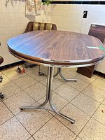 Round/oval laminate pedestal table top with chrome trim, chairs shown for scale only