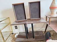 Speakers resting on media stand showing full lot