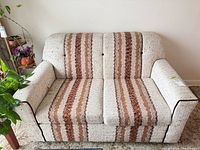 Front view of beige striped loveseat
