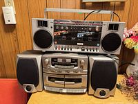 Stacked view showing Pro Sonic PQR7706 boombox above Lenoxx CD-155 stereo with left and right speakers
