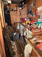 Overall view of narrow workshop showing bench, pegboard tools, tote, drawers, hardware on bench