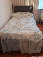 Full view of assembled twin bed showing headboard, mattress and bedding