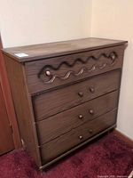 Front and side view of brown laminate dresser showing four drawers and decorative trim