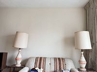 Both matching lamps on side tables beside sofa displaying shades and bodies