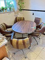 Dining set showing 4 matching swivel chairs around a table