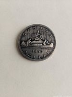 Reverse showing CANADA 1962 DOLLAR with voyageur canoe design