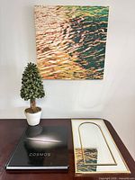 All four items grouped: canvas art, topiary, Cosmos book, mirror front
