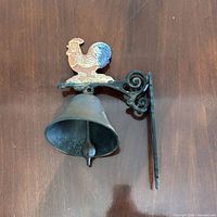 Front view showing rooster finial, bell, and scroll bracket