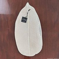 Top view of elongated silver ceramic leaf tray with tag attached