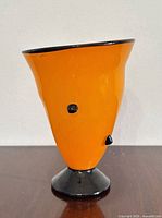 Front view showing orange body, black foot and accents