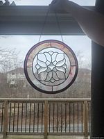 Full view of round stained glass panel hanging in window