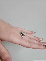 Ring on hand showing knot design and silver tone