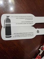 Instruction tag detailing strap, cup lid, and bottom opening features