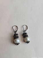 Front view of both earrings showing pearls, oxidized silver caps and leverbacks