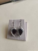 front view of earrings showing garnet stones and sterling silver setting