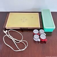 All items overview: warming tray, four enamel mugs, Tupperware container